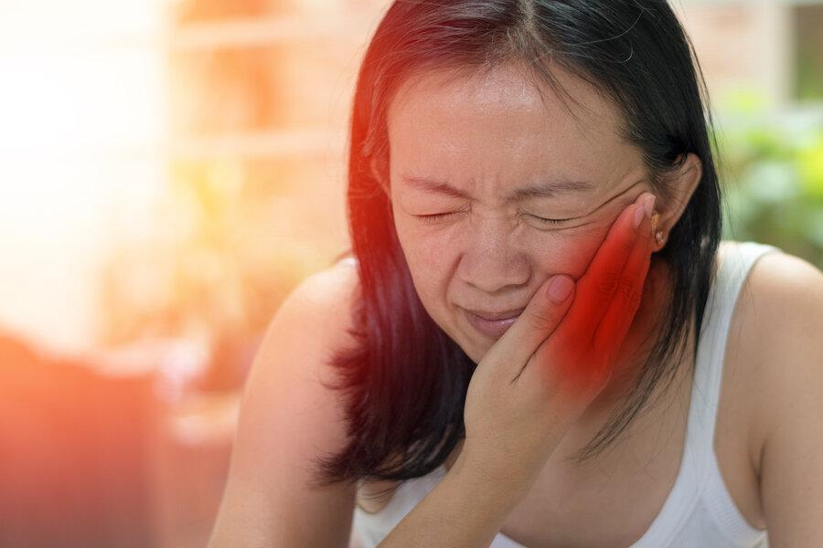 woman holding jaw from tooth pain