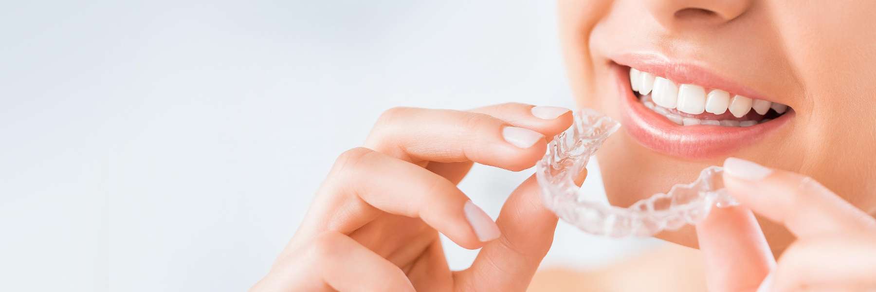 A woman putting in her Invisalign tray in Clifton Hill