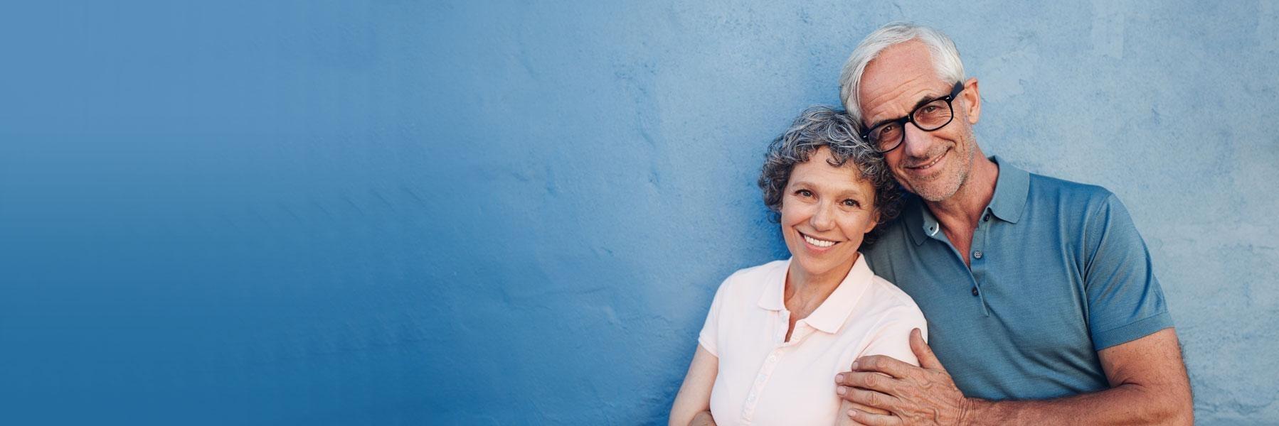 older couple with blue background smiling l dentist near me 3068
