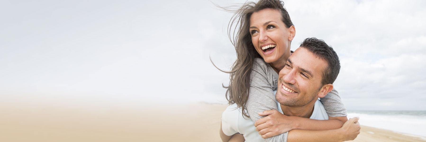 young couple smiling on beach l dentist thornbury