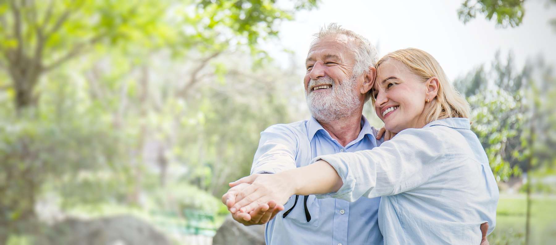 A smiling couple dancing in the park