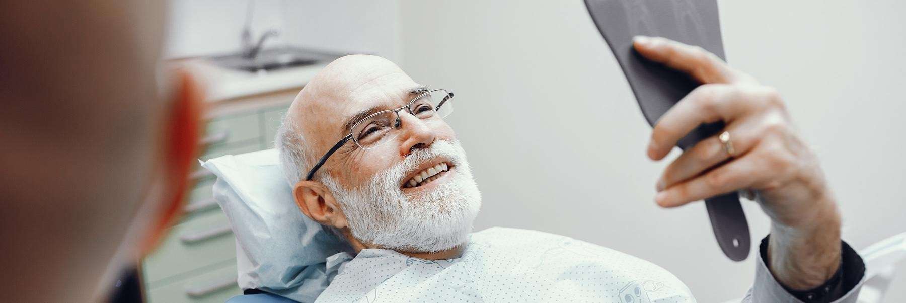 A dental patient examining his completed dental prostheses