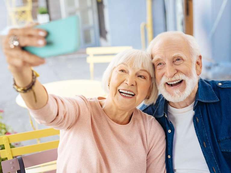 A smiling elderly couple taking a selfie