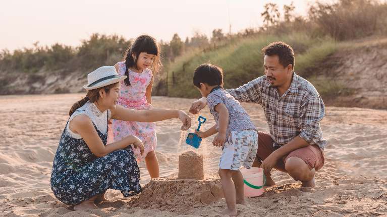 A family playing in the sand at the beach